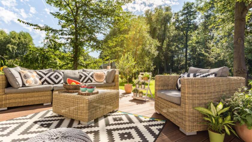 A cozy, well-furnished terrace in a spacious garden designed for outdoor living on a sunny day.