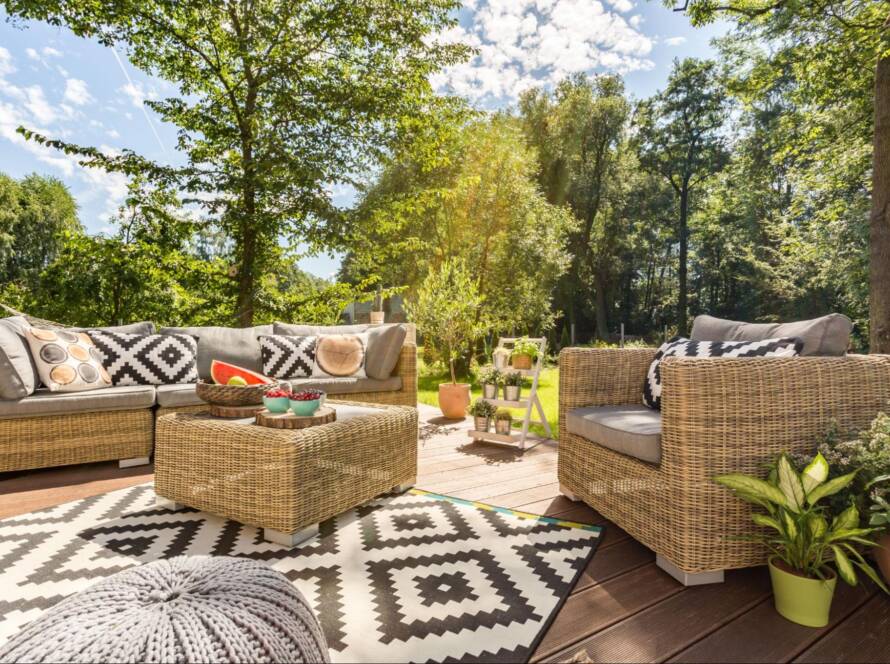 A cozy, well-furnished terrace in a spacious garden designed for outdoor living on a sunny day.
