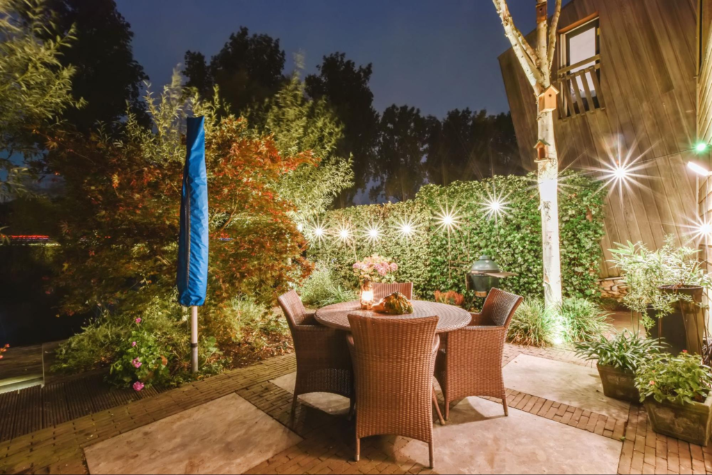 An outdoor patio with string lights over a round table.